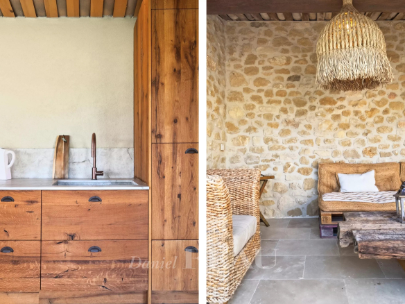 Intérieur d'une propriété rénovée avec cuisine en bois et salon en pierre à Lourmarin.