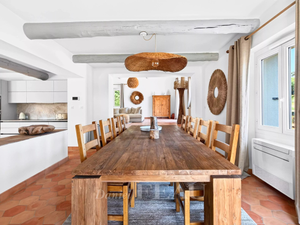 Salle à manger avec grande table en bois et décoration intérieure moderne.