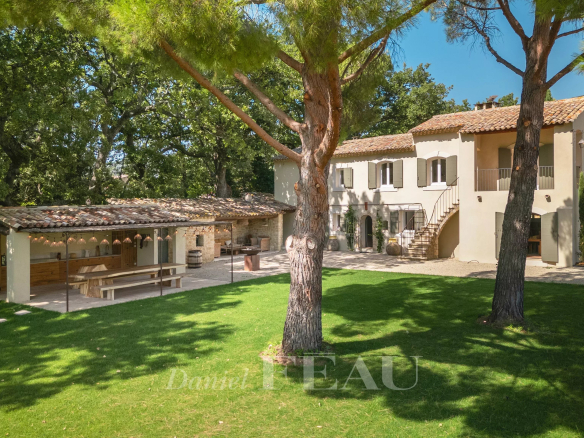 Propriété rénovée avec jardin et terrasse à Lourmarin, entourée d'arbres.