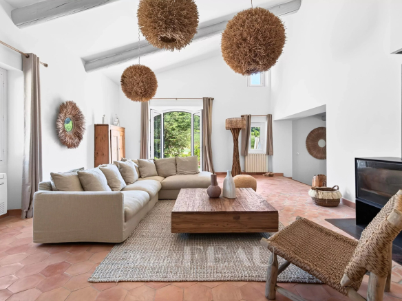 Intérieur d'une maison rénovée avec un salon spacieux, des meubles modernes et des éléments naturels.