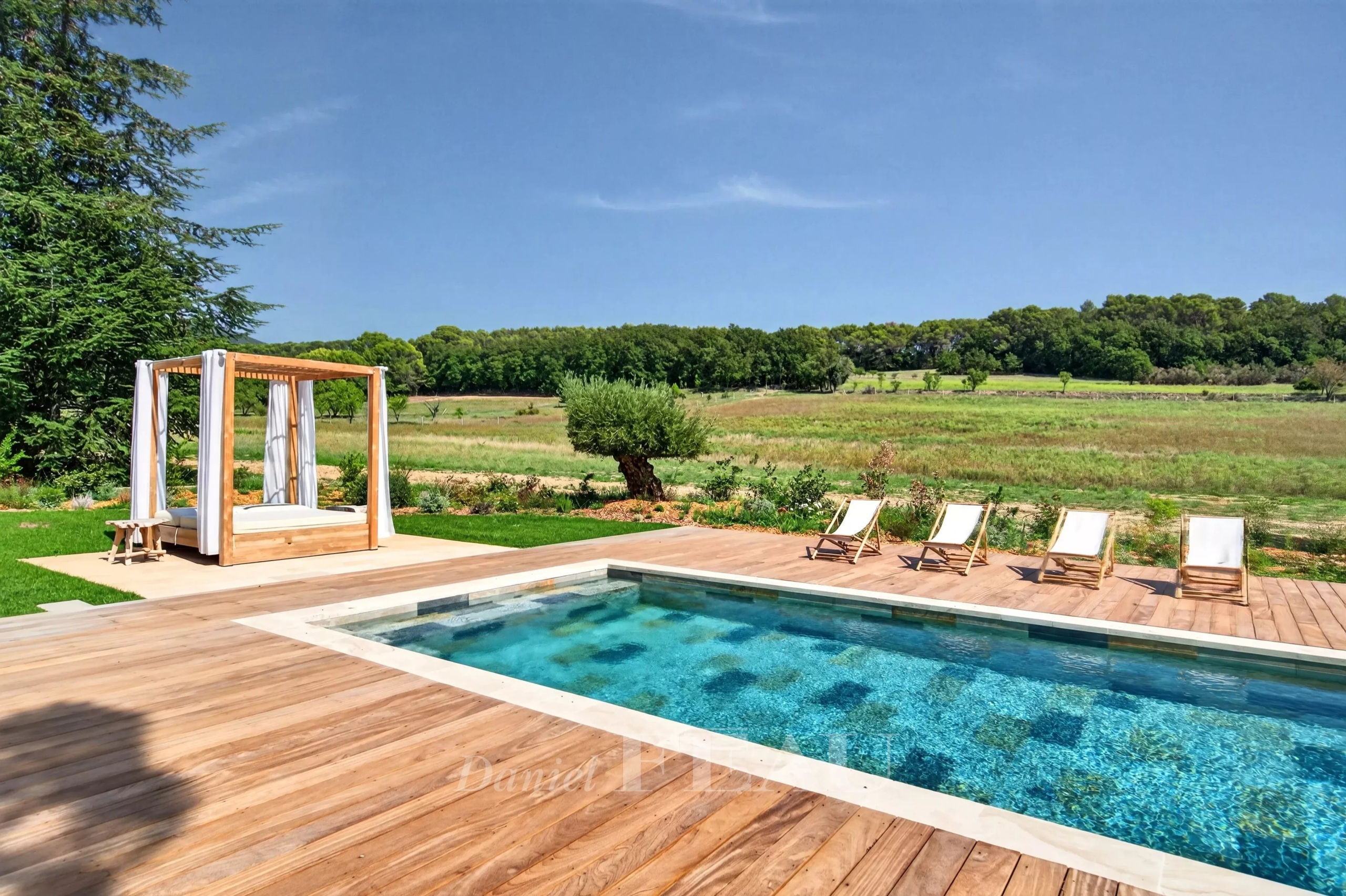 Propriété rénovée avec piscine à Lourmarin Piscine avec chaises longues et espace détente dans une propriété rénovée à Lourmarin, entourée de nature.