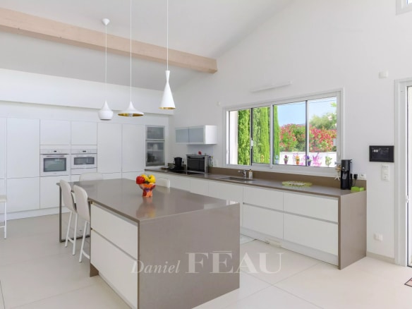 Intérieur d'une villa contemporaine avec cuisine moderne et îlot central à Saint-Cyr-sur-Mer.