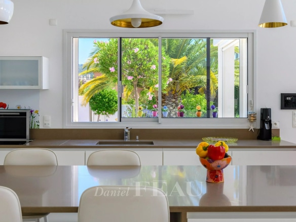 Intérieur d'une villa contemporaine à Saint-Cyr-sur-Mer avec cuisine moderne et vue sur le jardin.