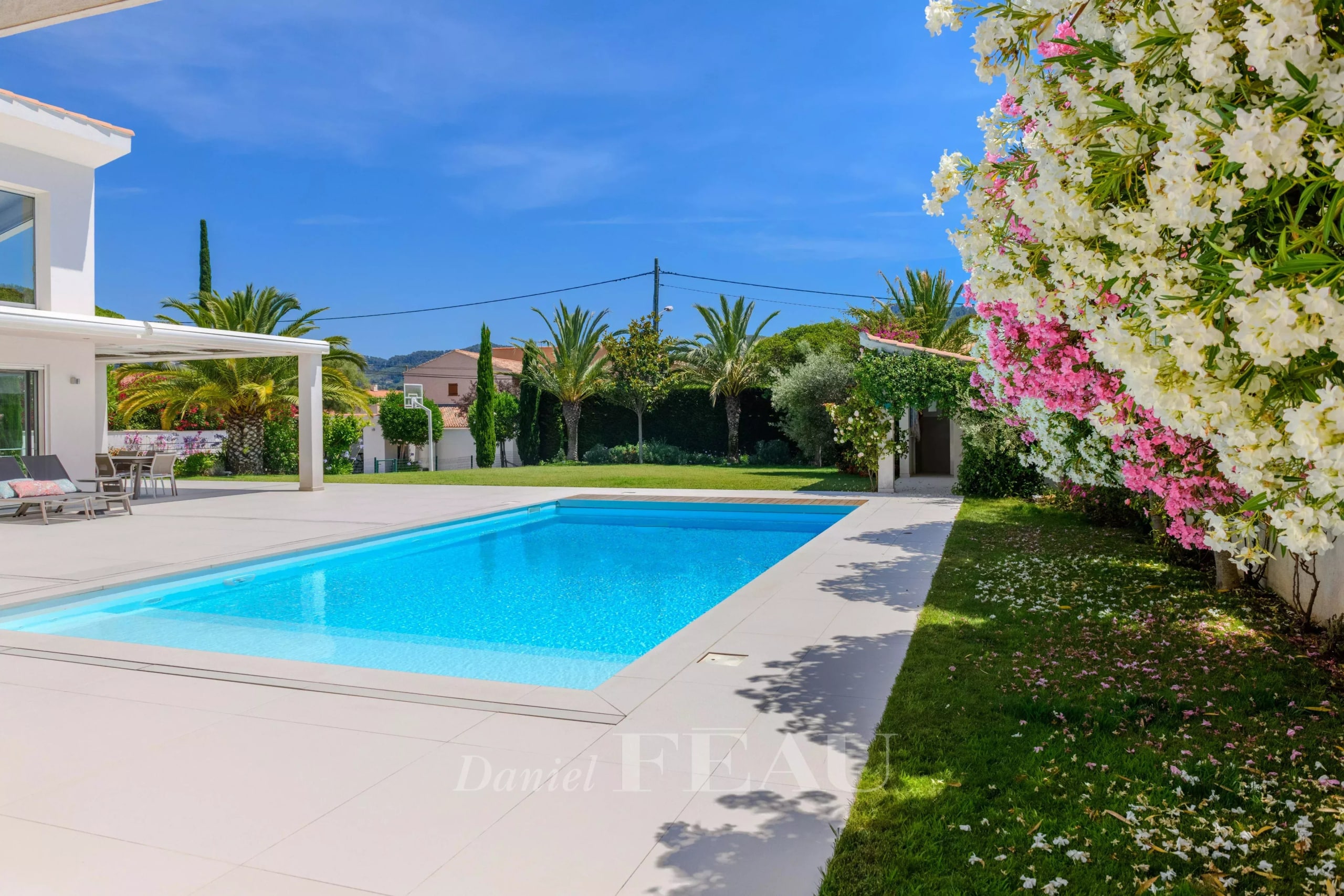 Villa contemporaine à Saint-Cyr-sur-Mer Villa contemporaine avec piscine à Saint-Cyr-sur-Mer, jardin paysager et ciel bleu.