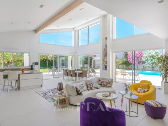 Intérieur d'une villa contemporaine à Saint-Cyr-sur-Mer, avec un séjour lumineux et une vue sur la piscine.