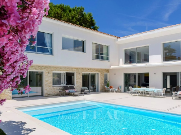 Villa contemporaine avec piscine à Saint-Cyr-sur-Mer, entourée de fleurs et de verdure.
