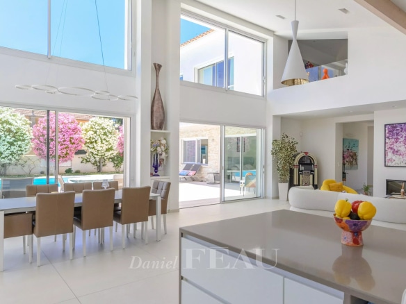 Intérieur d'une villa contemporaine à Saint-Cyr-sur-Mer, avec un grand séjour lumineux et une cuisine ouverte.