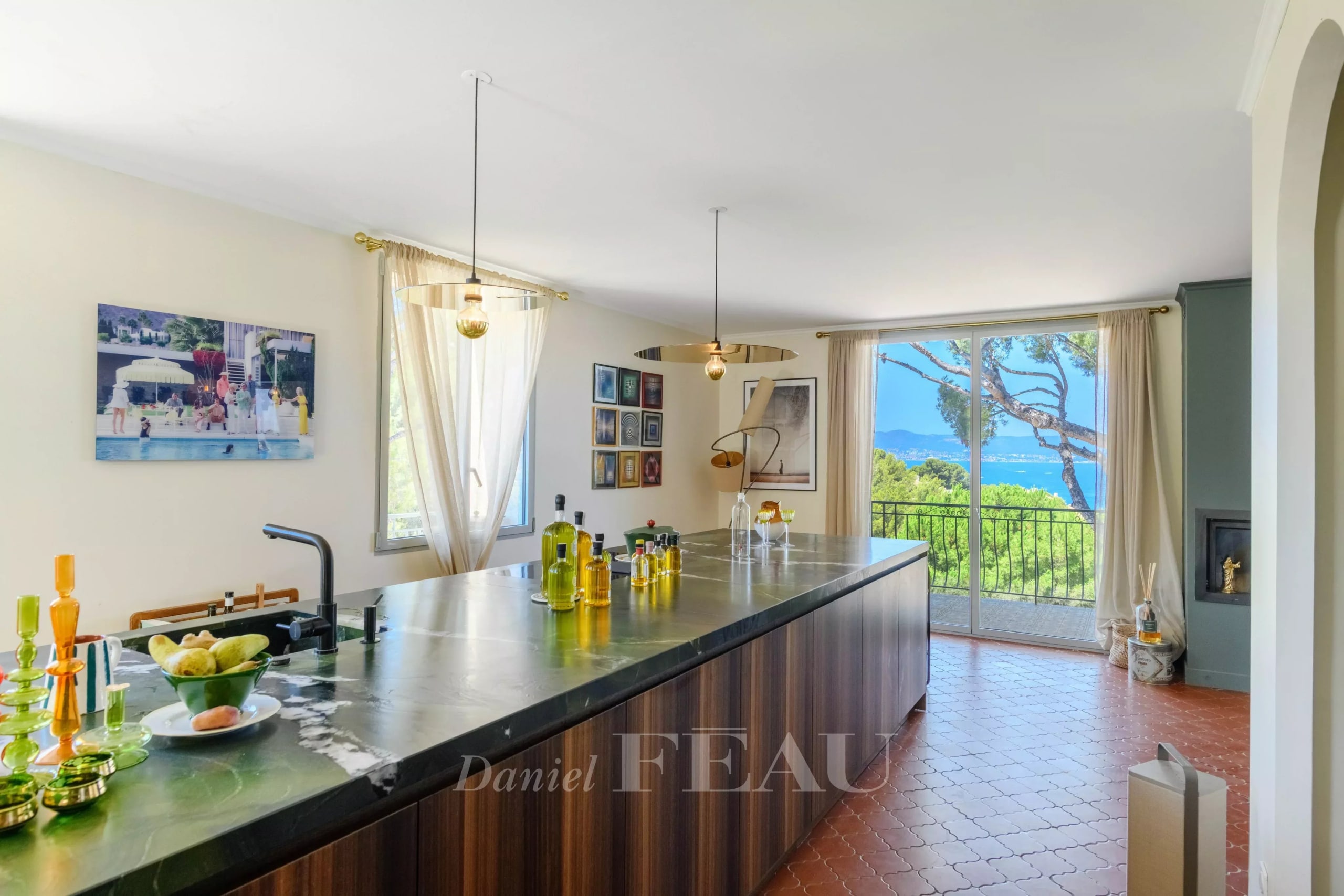 Intérieur d'une maison rénovée avec vue sur la mer, cuisine moderne et baies vitrées.