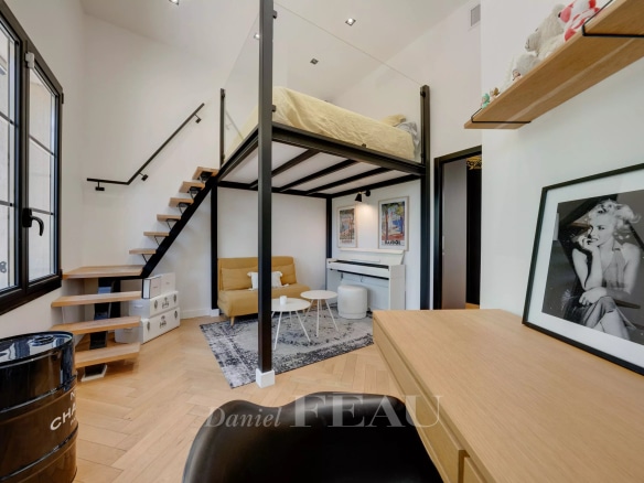 Interior of an apartment with a mezzanine, wooden staircase and modern furniture.