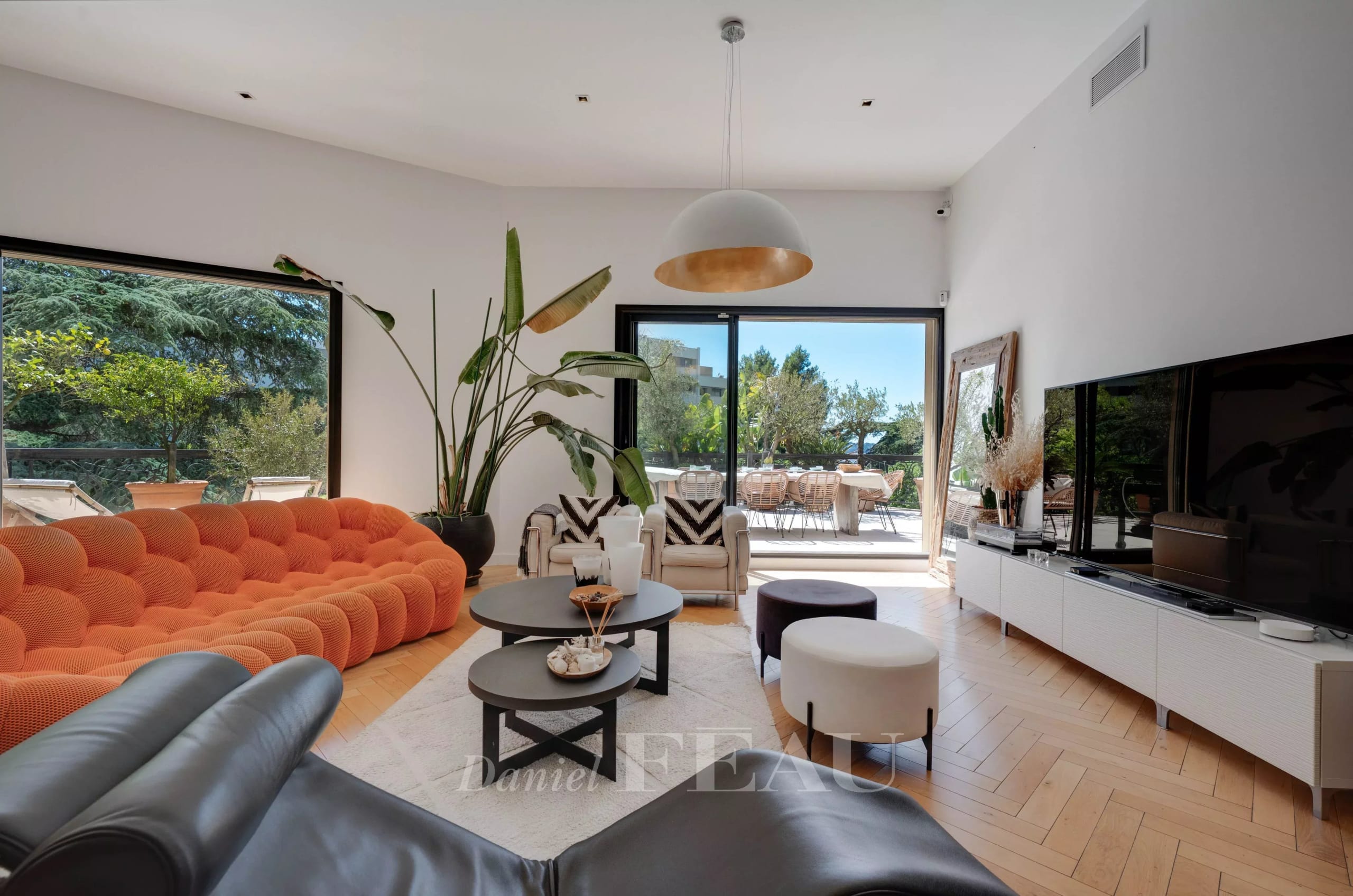 Living room of an apartment with an orange sofa and a view of a terrace in Marseille 9th arrondissement.