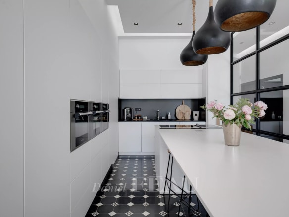 Modern kitchen with central island and integrated appliances in a luxury apartment.