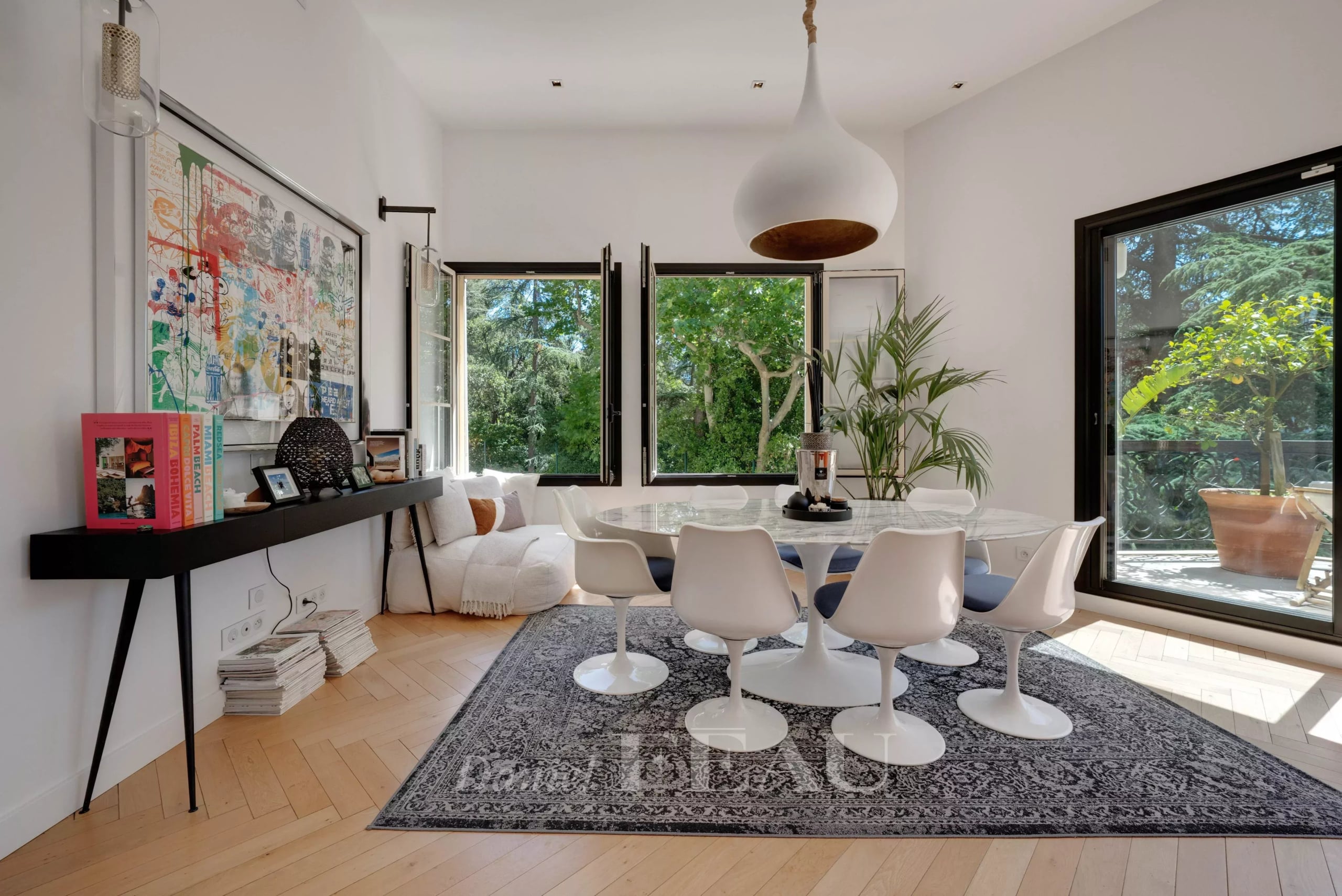 Modern dining room with large windows and views of nature, apartment in Marseille 9th arrondissement.