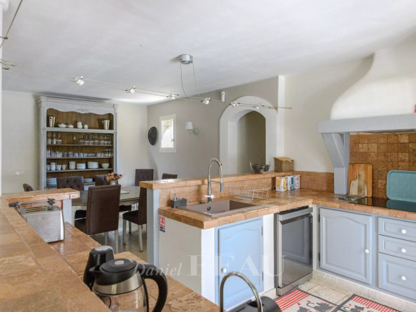 Kitchen of a Provençal house with modern elements, open to a dining room.