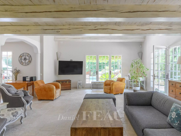 Interior of a property with a spacious living room, sofas and large windows.