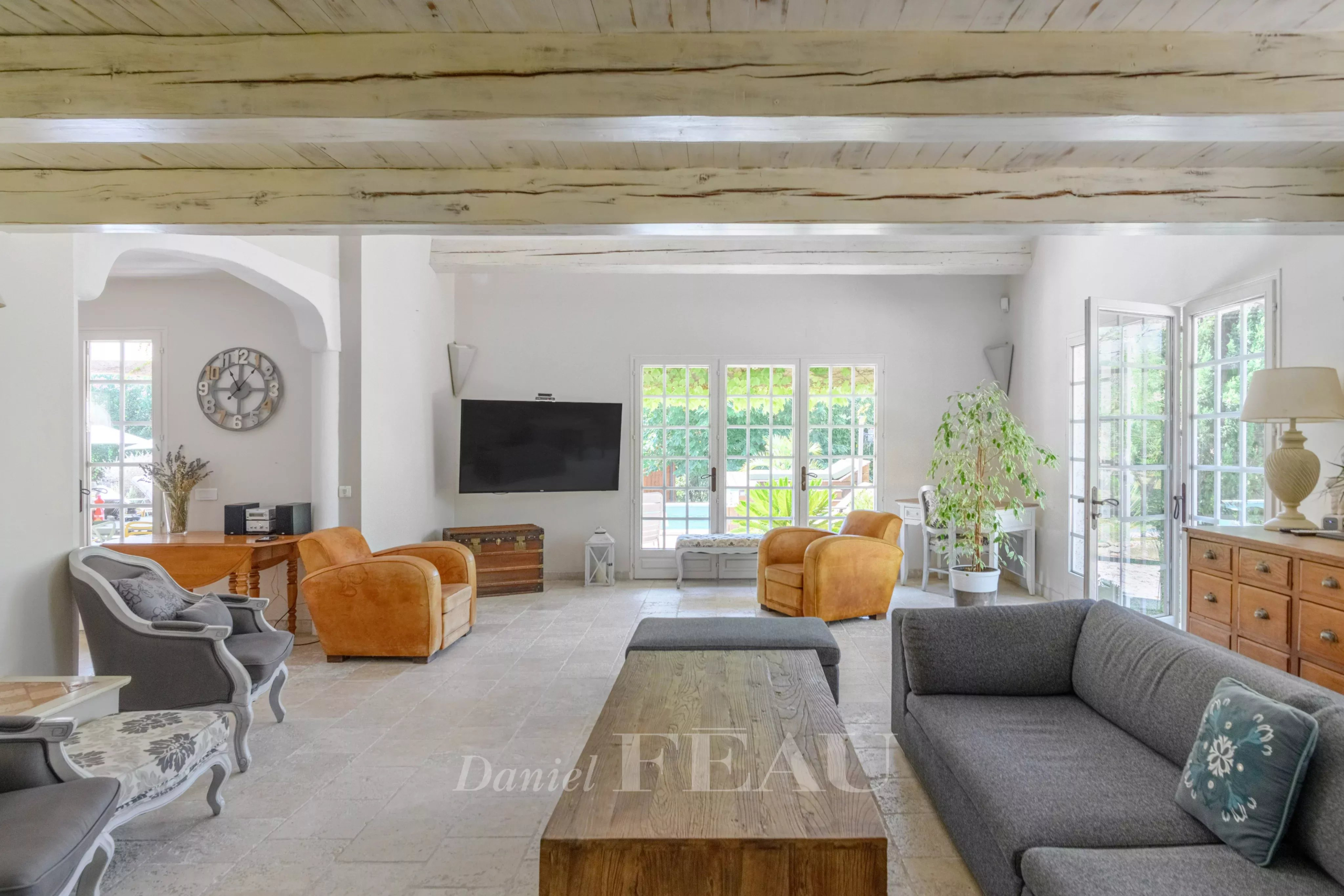 Interior of a property with a spacious living room, sofas and large windows.