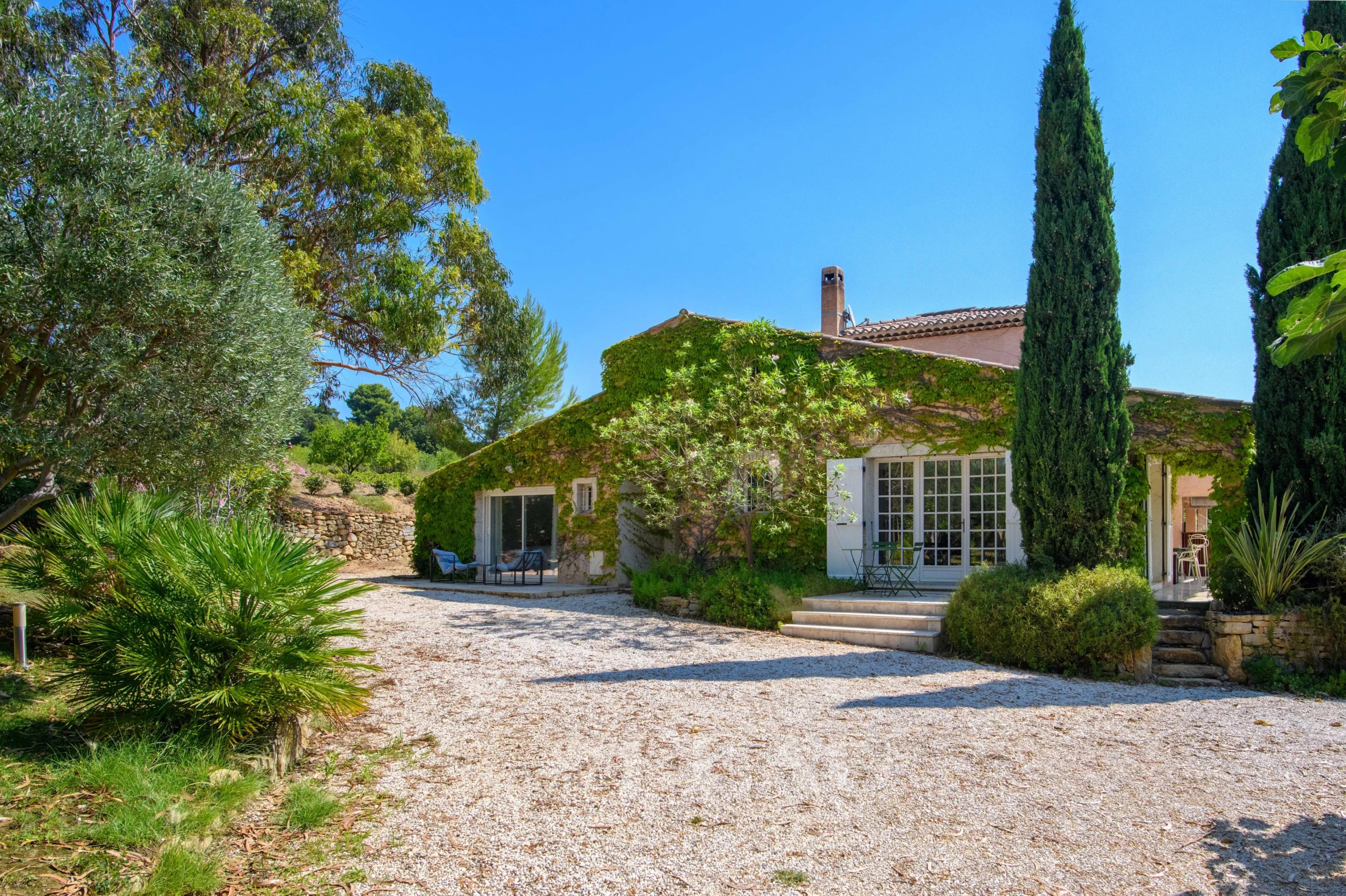 Property with two houses and gardens in Saint-Cyr-sur-Mer, surrounded by trees and green space.