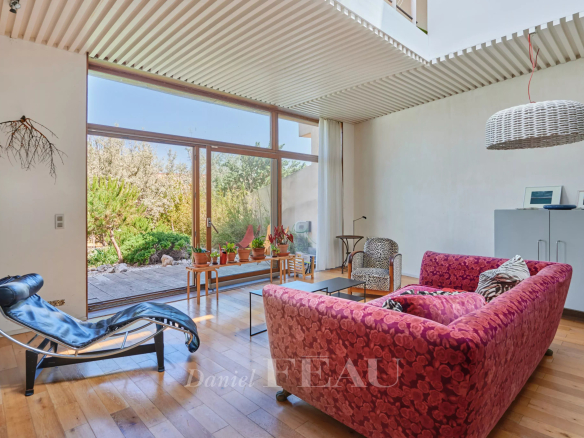 Intérieur d'une maison moderne avec un salon lumineux et un accès à un jardin.