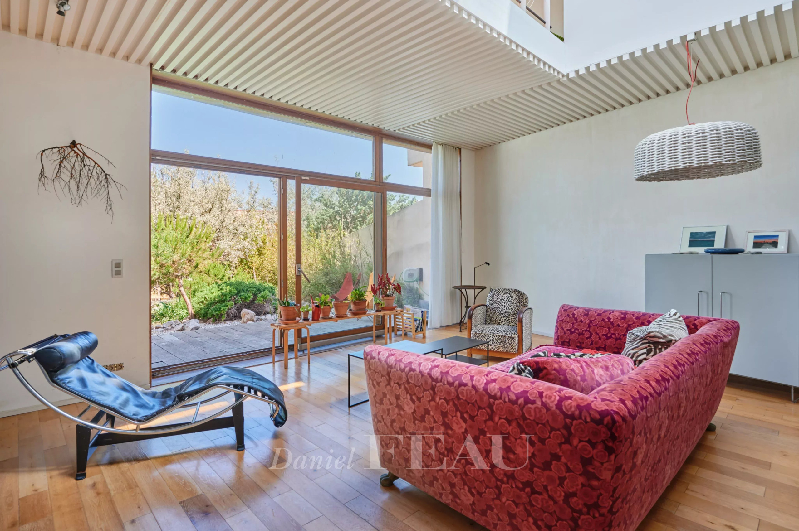 Intérieur d'une maison moderne avec un salon lumineux et un accès à un jardin.