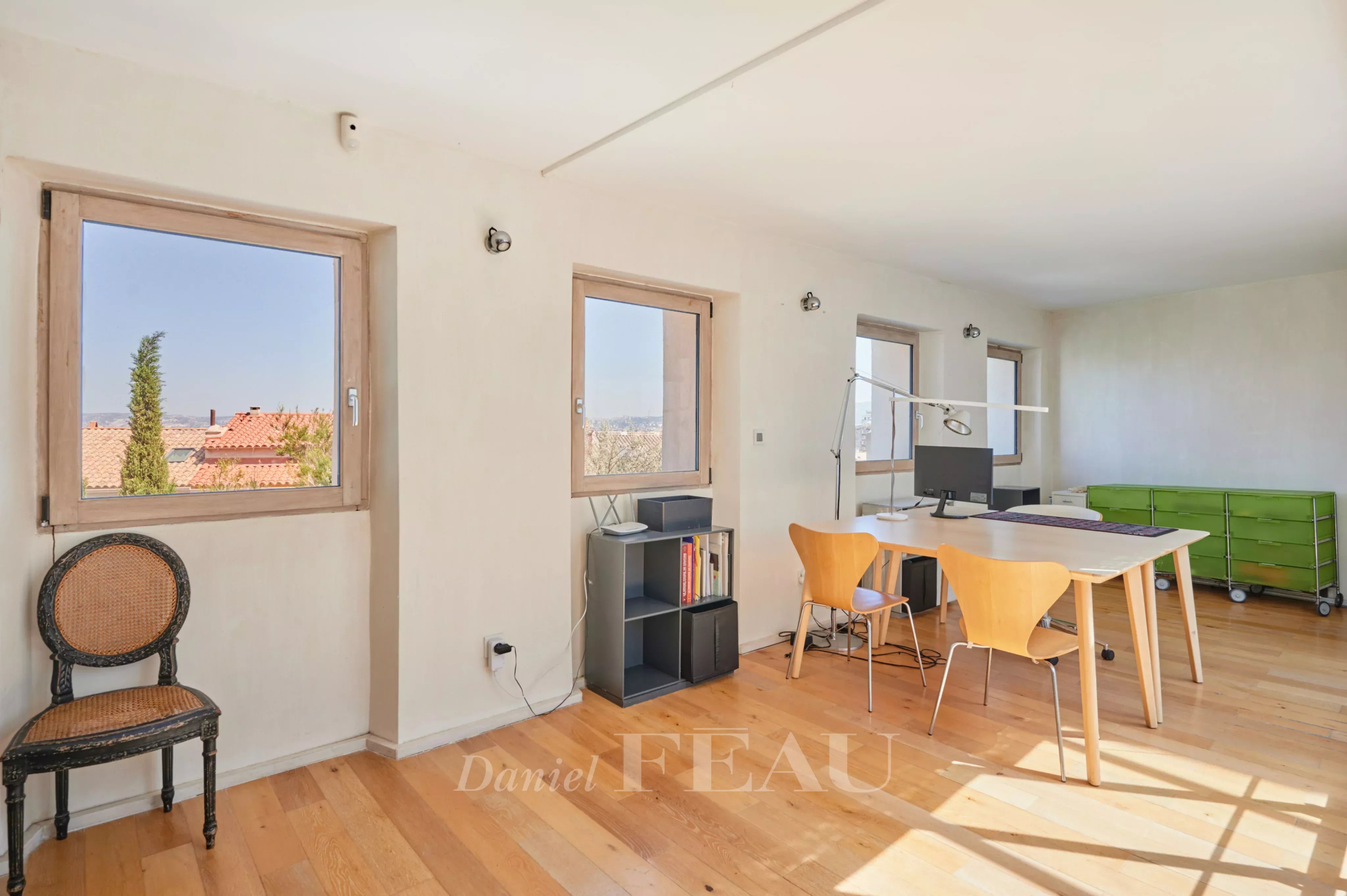 Intérieur lumineux d'une maison à Marseille 7ème, avec fenêtres et mobilier moderne.