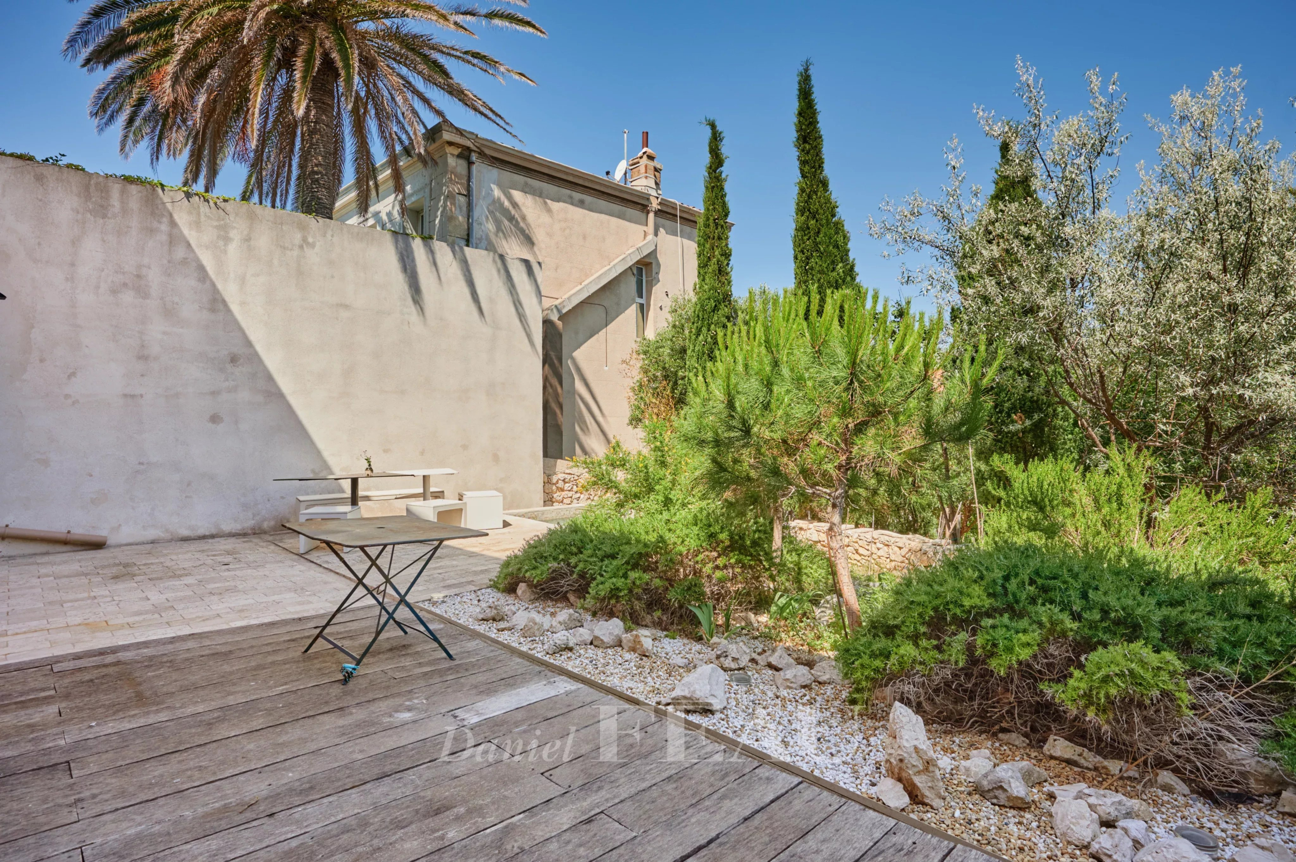 Jardin d'une maison à Marseille 7ème avec des plantes et un espace extérieur en bois.