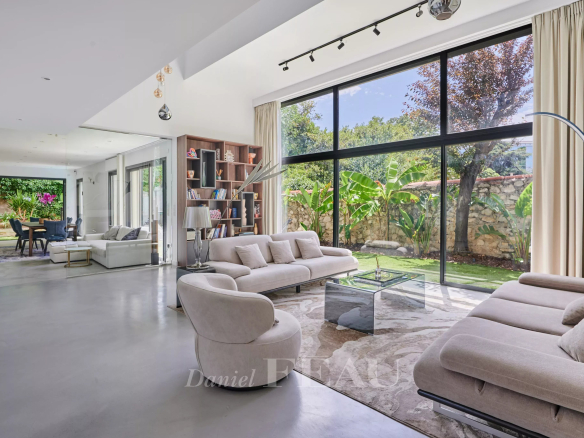 Intérieur d'une maison contemporaine avec salon lumineux et vue sur le jardin.