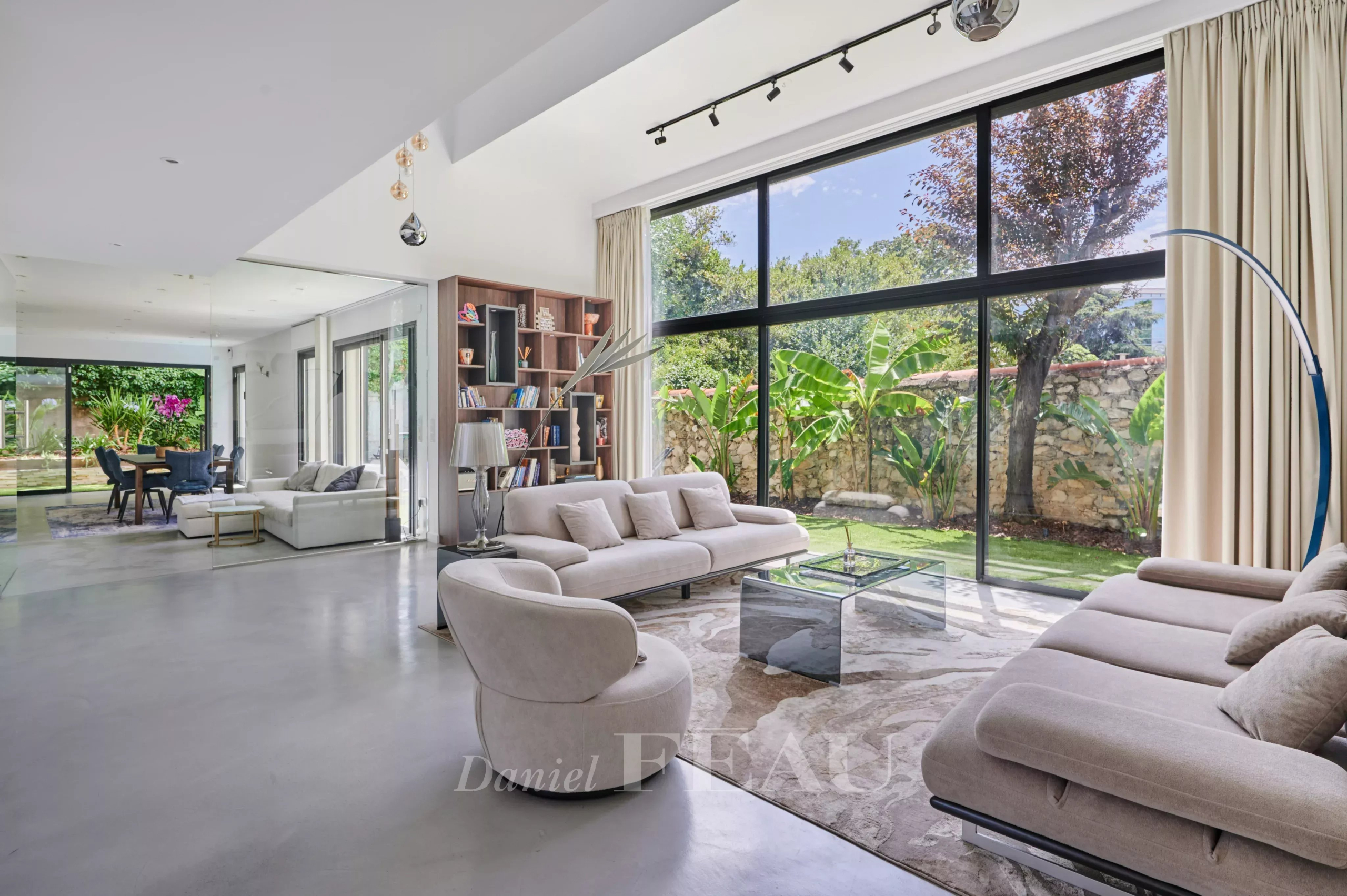 Intérieur d'une maison contemporaine avec salon lumineux et vue sur le jardin.