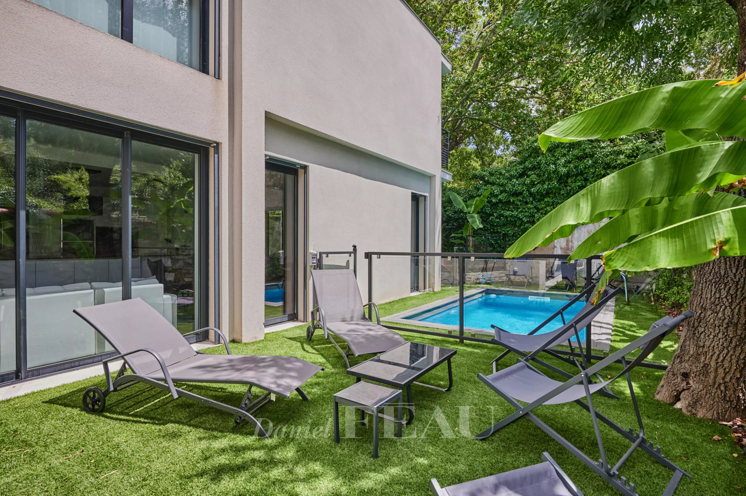 Terrasse d'une maison contemporaine avec chaises longues et piscine à Marseille 8ème.