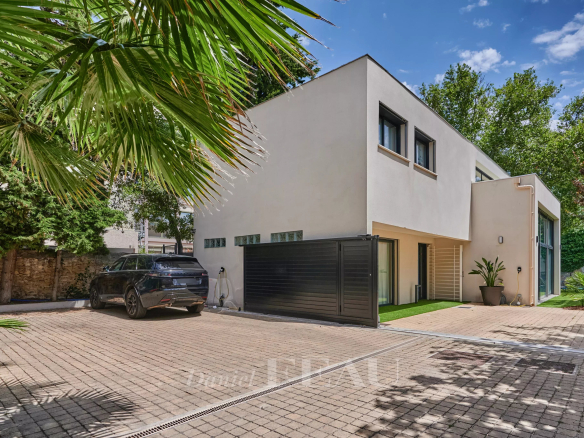 Maison contemporaine avec piscine à Marseille 8ème, vue extérieure avec jardin et véhicule.