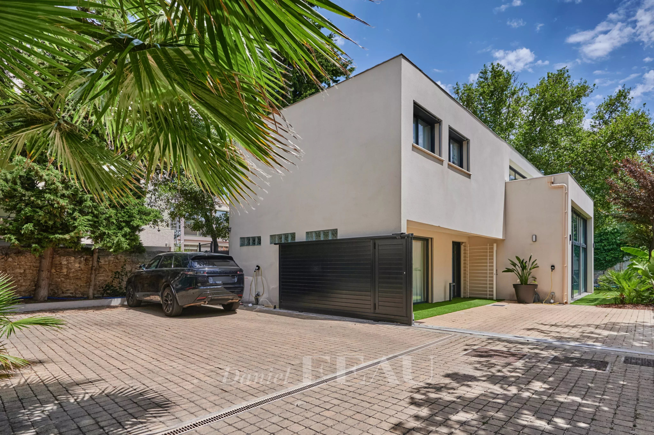 Maison contemporaine avec piscine à Marseille 8ème, vue extérieure avec jardin et véhicule.