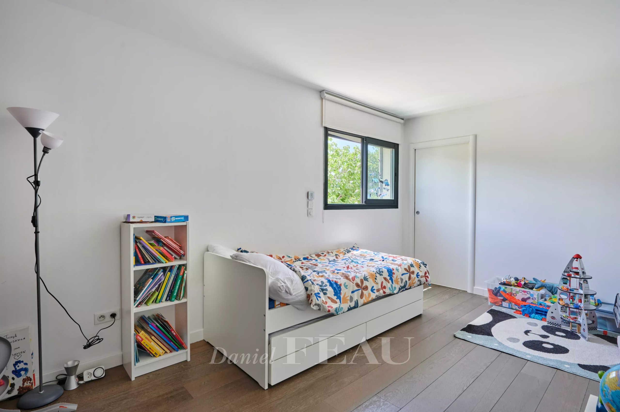 Chambre d'une maison contemporaine à Marseille 8ème avec lit simple et étagère de livres.