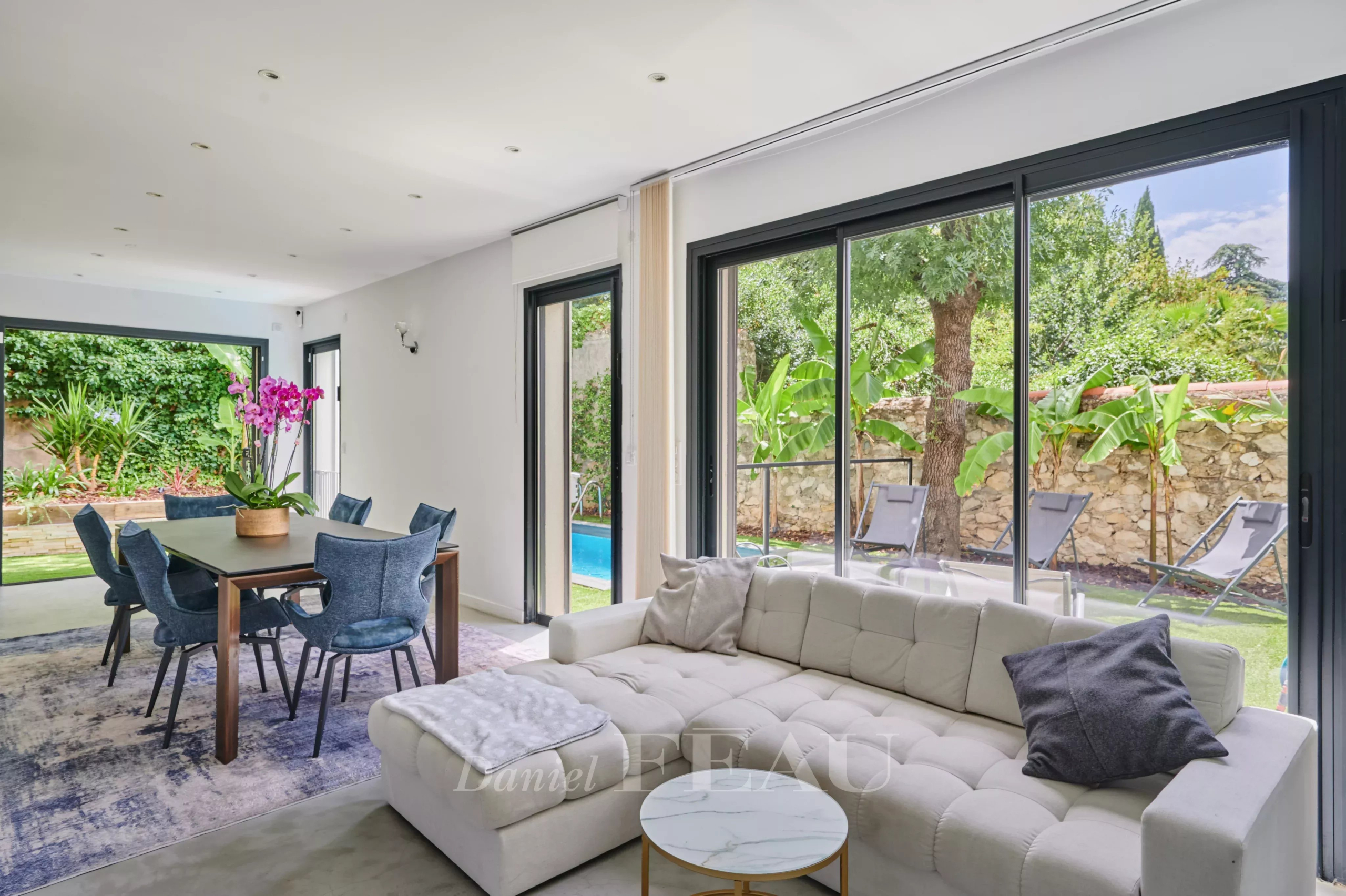 Intérieur d'une maison contemporaine à Marseille 8ème avec salon, salle à manger et vue sur le jardin.