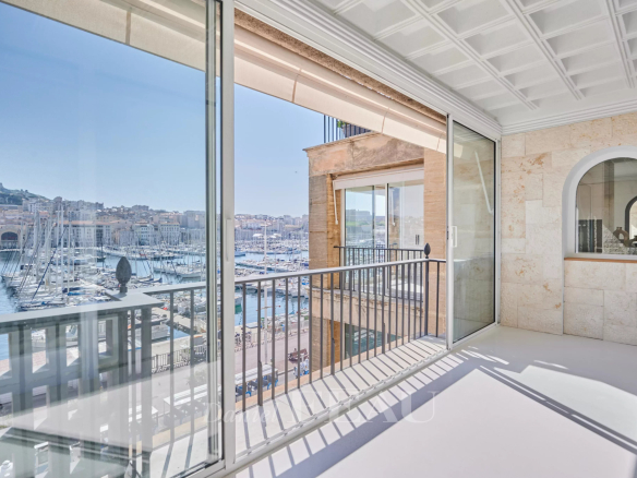 Vue panoramique depuis un appartement rénové à Marseille, montrant le Vieux-Port et la Bonne Mère.