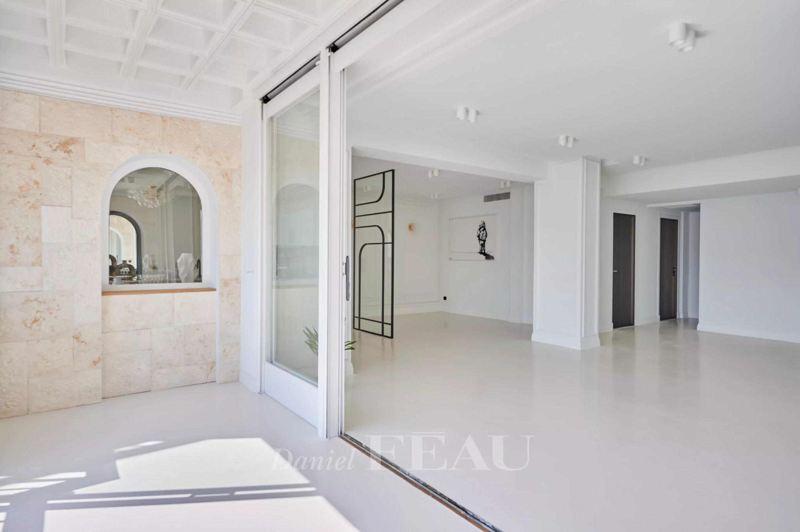 Intérieur d'un appartement rénové avec vue sur le Vieux-Port à Marseille, murs clairs et espace lumineux.