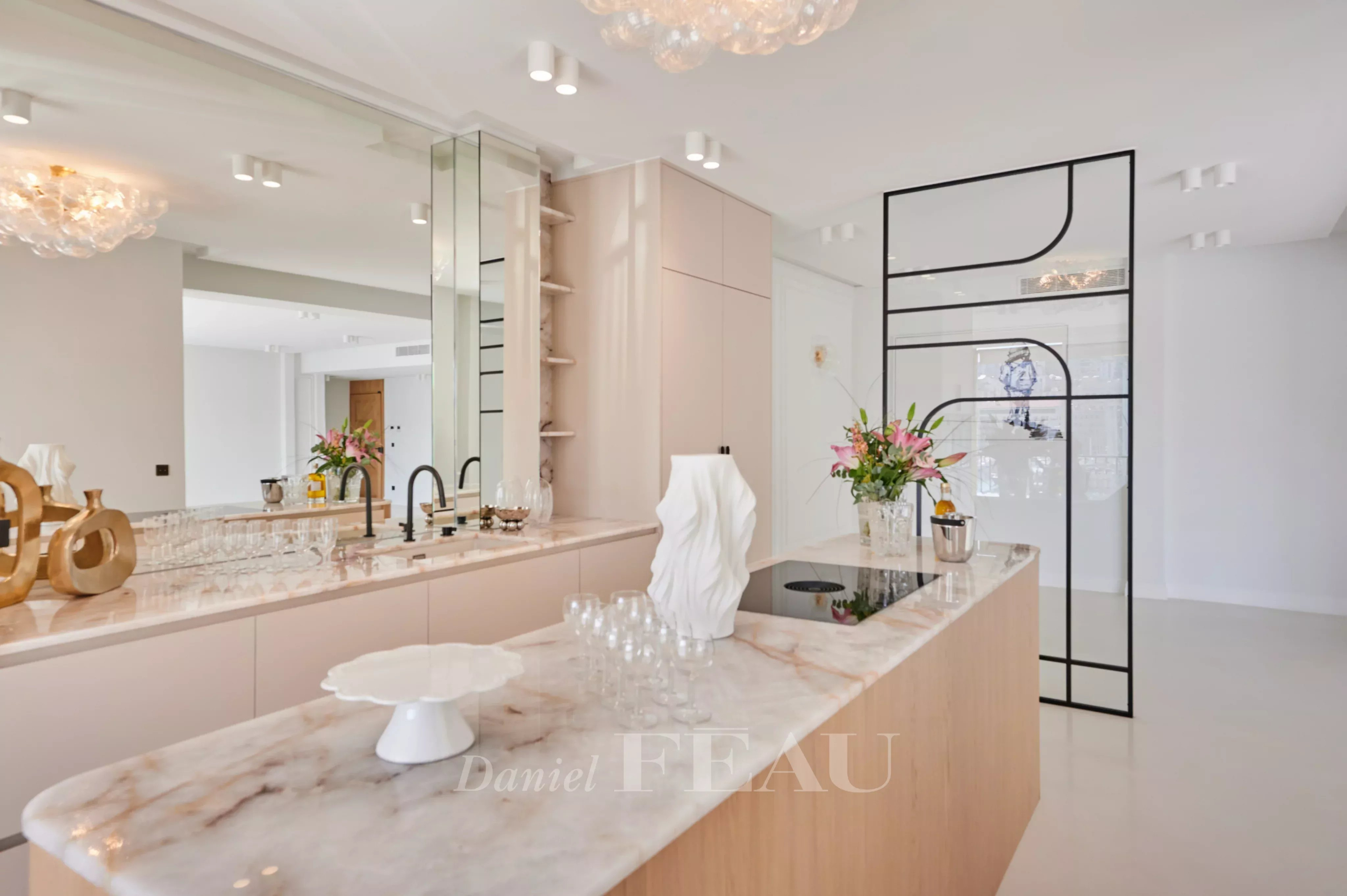 Cuisine moderne avec îlot central et décoration épurée dans un appartement rénové à Marseille.