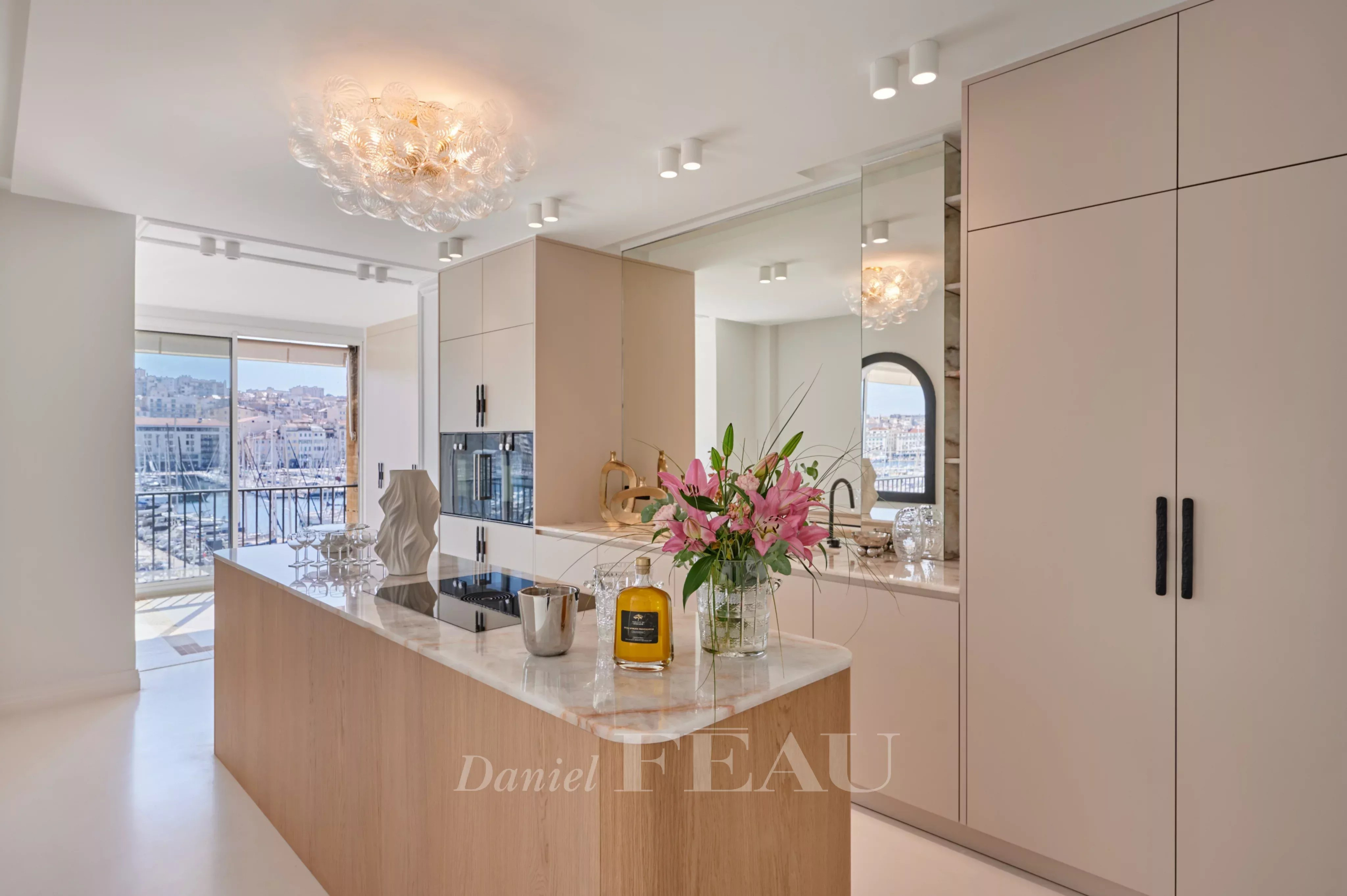 Cuisine moderne et lumineuse d'un appartement rénové à Marseille, avec vue sur le Vieux-Port.