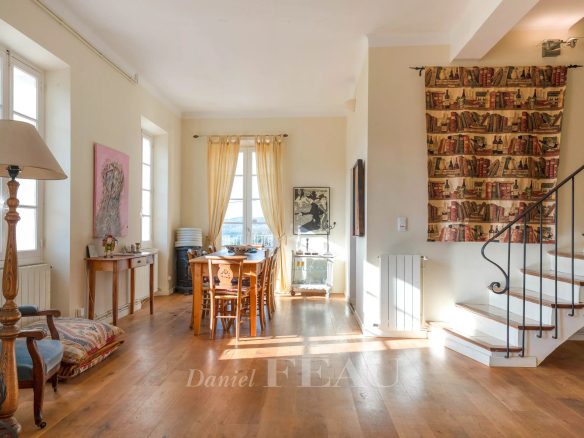 Intérieur d'une maison de caractère avec salon lumineux et coin repas.