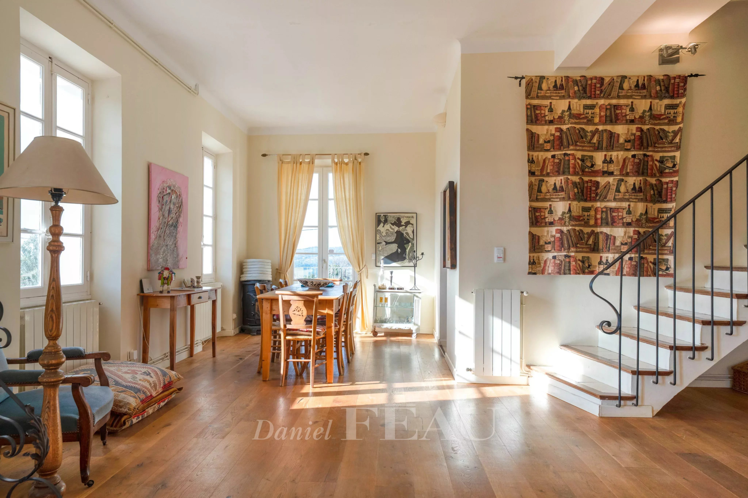 Intérieur d'une maison de caractère avec salon lumineux et coin repas.