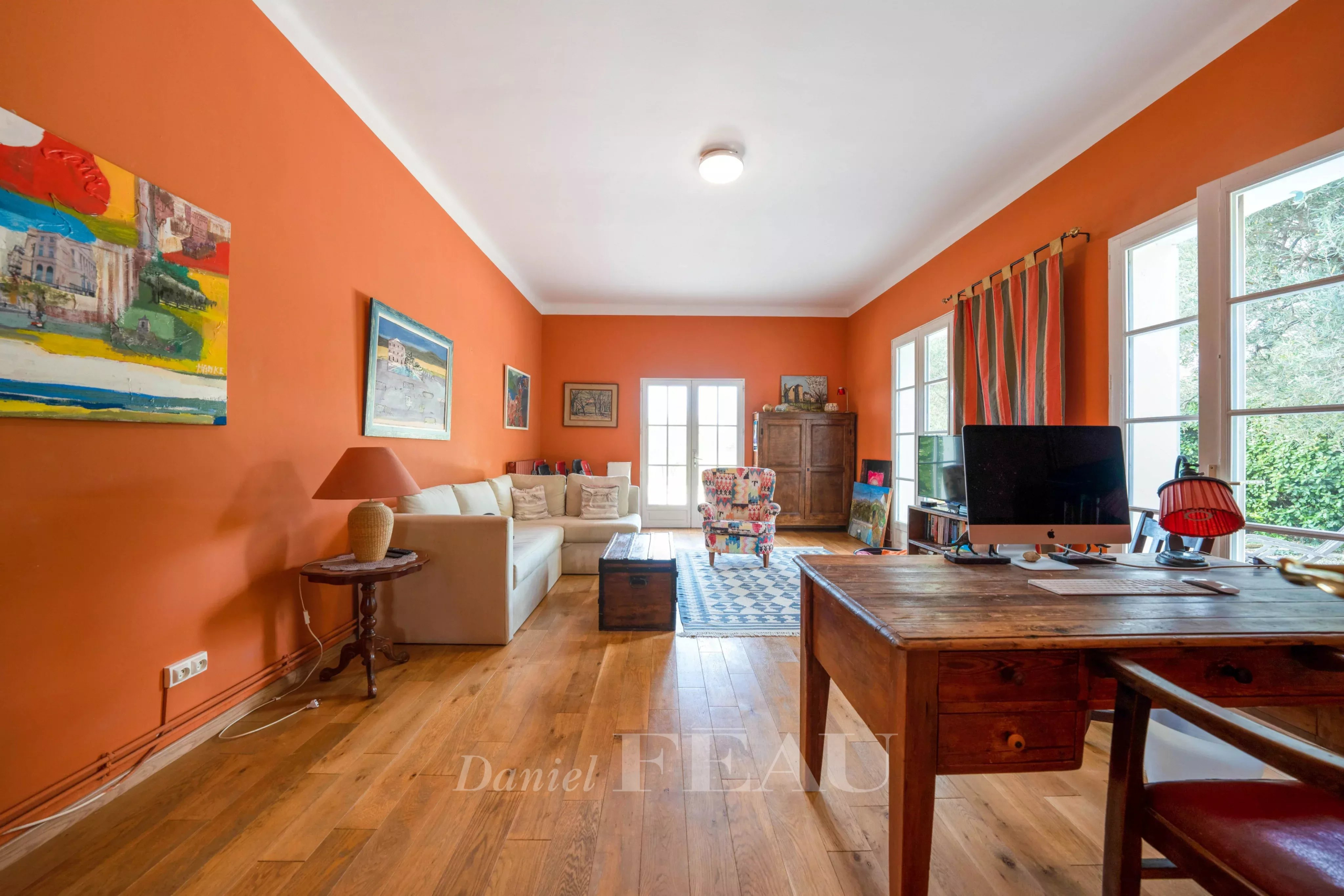 Intérieur d'une maison de caractère avec murs orange et mobilier en bois, Le Castellet.