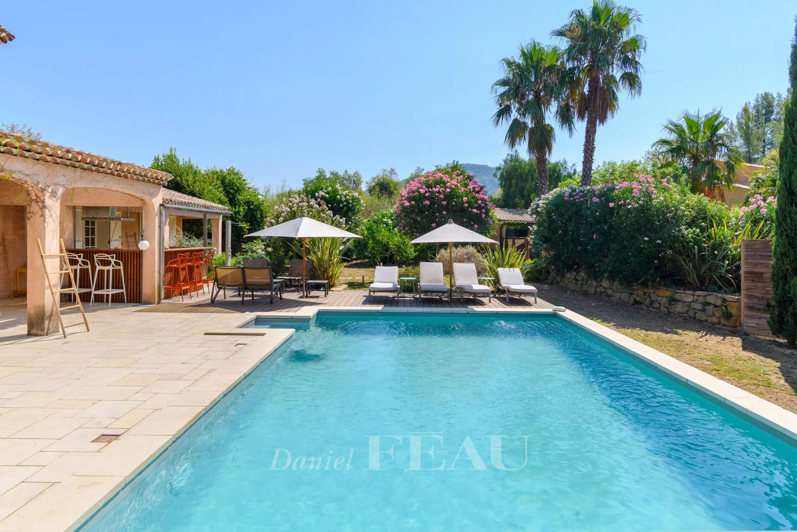Piscine chauffée et sécurisée entourée de transats et de parasols dans un domaine provençal.