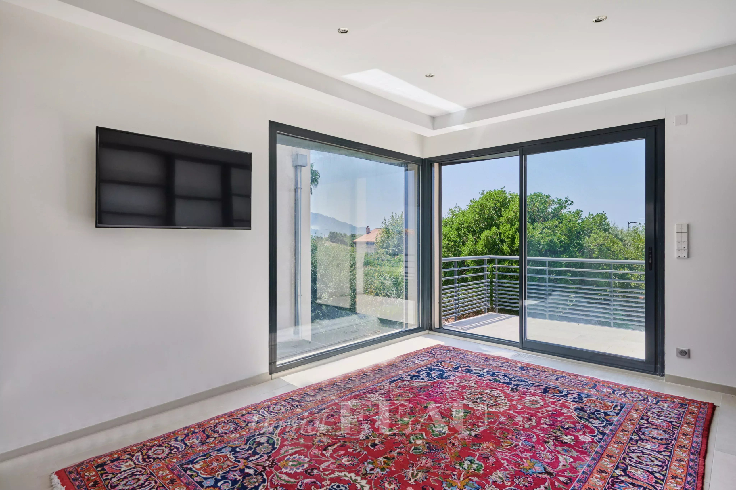 Intérieur d’une maison familiale à Marseille 8ème Intérieur lumineux d'une maison avec un tapis persan et de grandes fenêtres donnant sur l'extérieur.