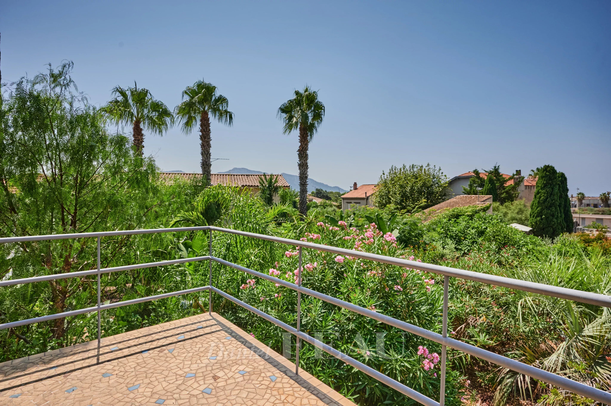 Terrasse dans une maison à Marseille 8ème Terrasse avec vue sur des palmiers et des jardins à Marseille 8ème.