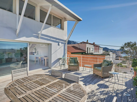 Terrasse en bois avec mobilier extérieur et vue sur la mer à Marseille 8ème.