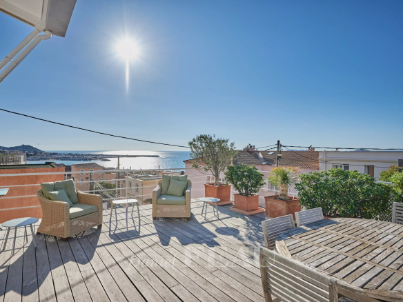 Terrasse en bois avec vue sur la mer à Marseille, ensoleillée et calme.