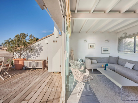 Intérieur d'une maison de ville à Marseille avec un salon lumineux et un accès à une terrasse en bois.