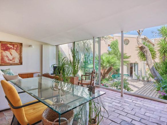 Intérieur d'une maison de ville à Marseille avec vue sur la mer, plantes et mobilier moderne.