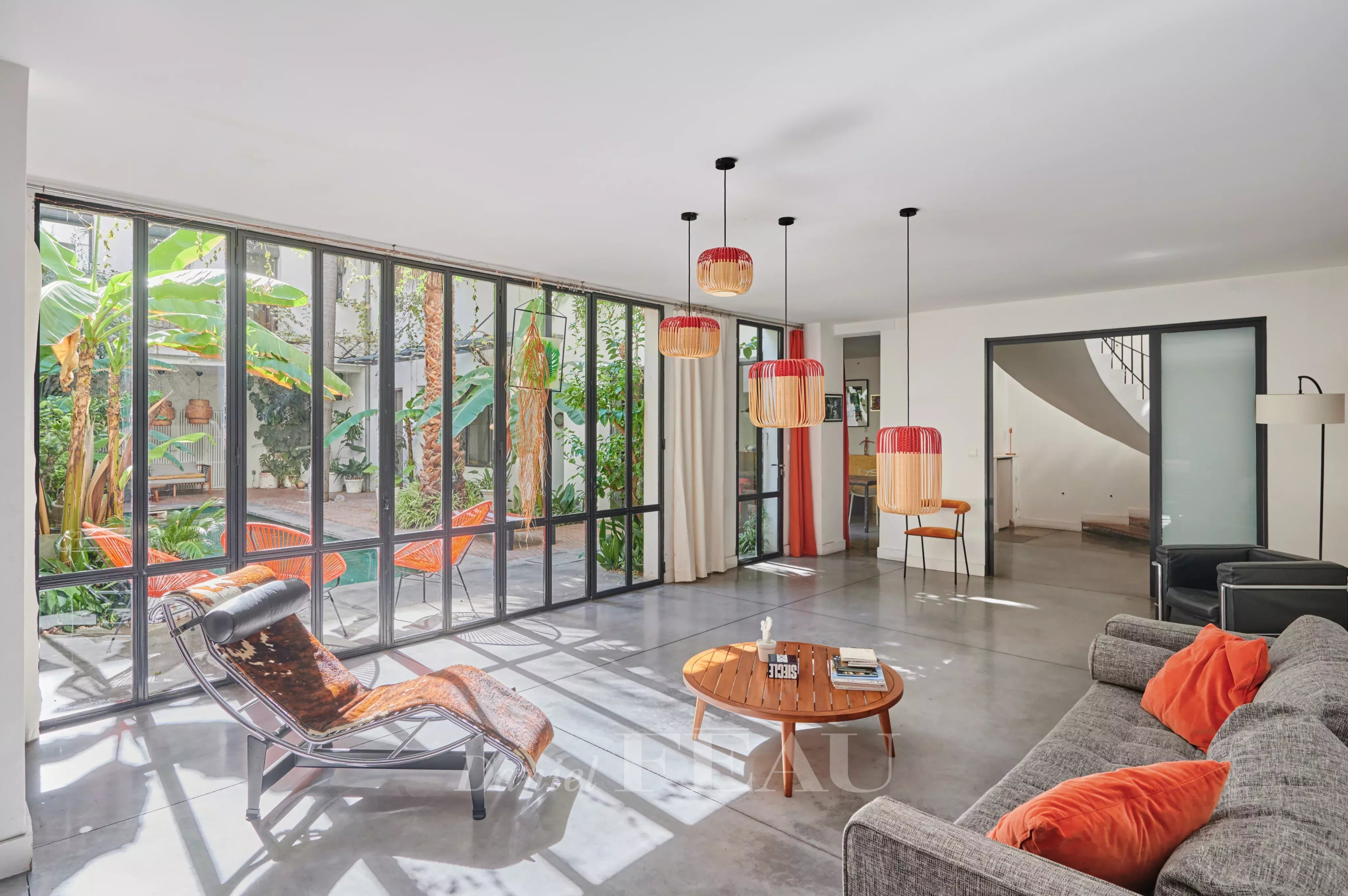 Modern house in Marseille 7th arrondissement Interior of a house in Marseille 7th district with a bright living room and a view of a green patio.
