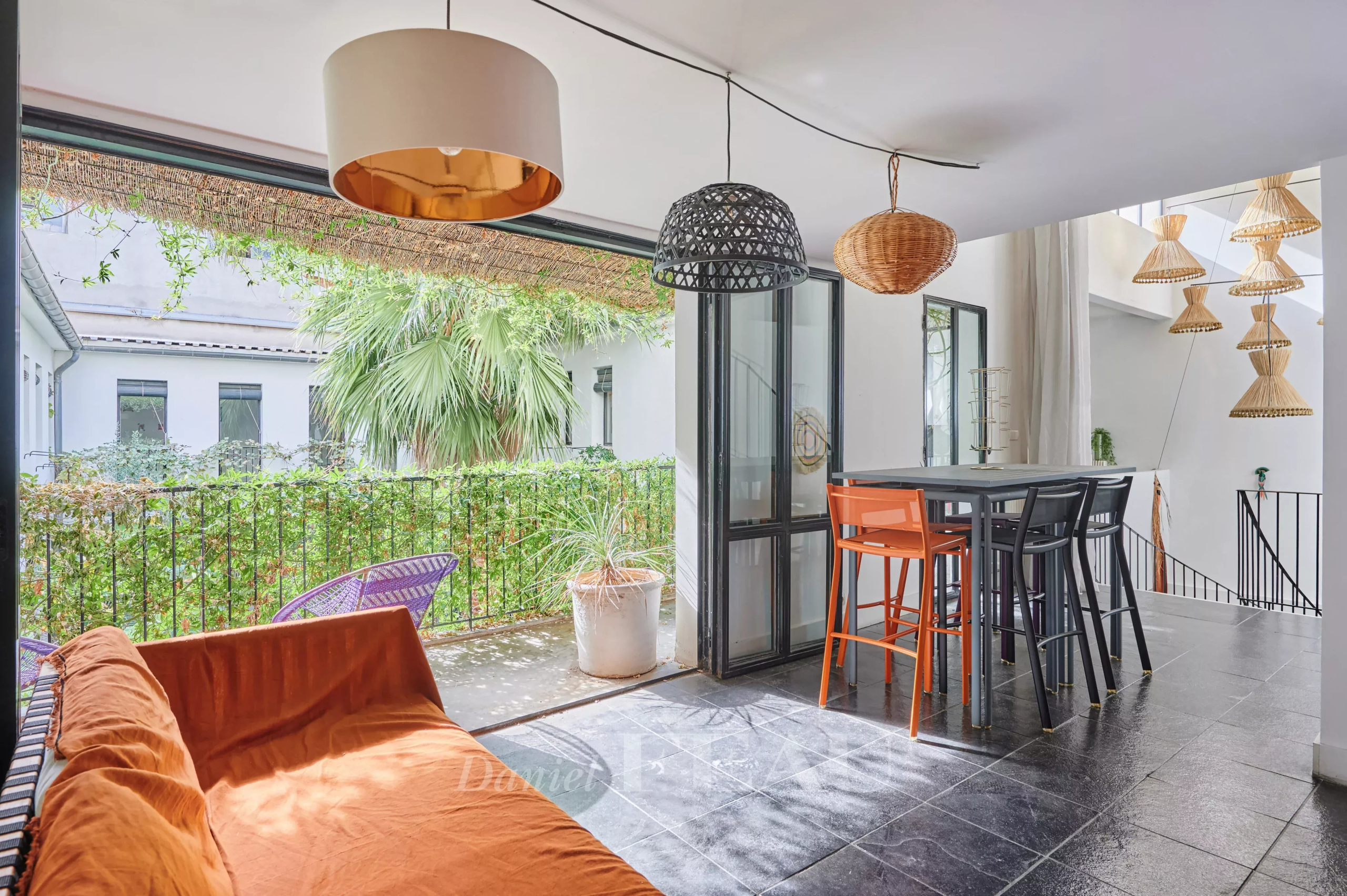 House with pool in Marseille 7th arrondissement Interior of a house in Marseille 7th district with living room, high table and view of a green patio.