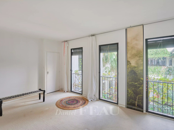 Interior of a house in Marseille 7th district with windows overlooking a green patio.