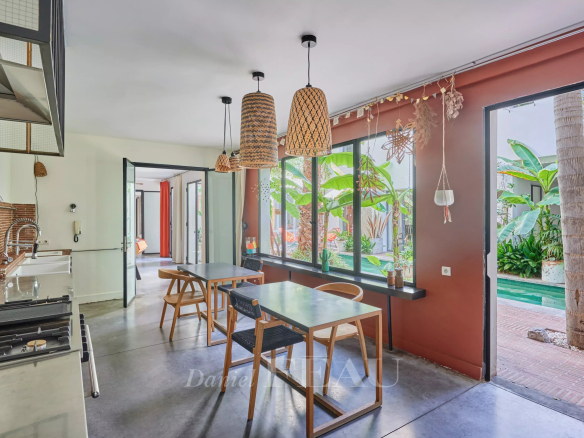 Interior of a house in Marseille 7th district with open kitchen and view of a green patio.