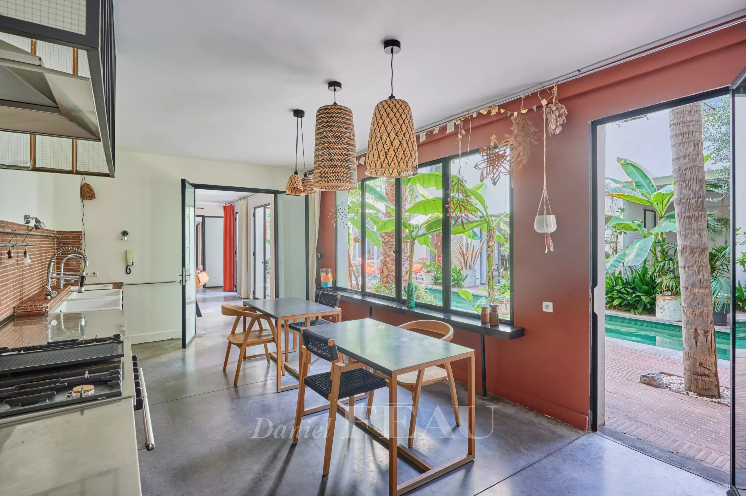 House with pool in Marseille 7th arrondissement Interior of a house in Marseille 7th district with open kitchen and view of a green patio.